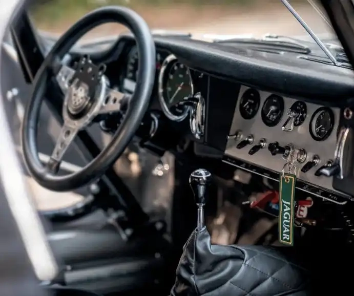 1961 Jaguar E-type OTS roadster - interior - The backdrop seems so incongruous: an area of protected woodland in central Lisbon bisected by a busy thoroughfare. However, this same spot in the Portuguese capital once resonated to the sound of Grand Prix weaponry, the street circuit having played host to a round of the Formula 1 World Championship in 1959. It is also the venue at which this ‘flat floor’ roadster once vanquished all-comers in the early 1960s. More than once, in fact. This old warhorse saw action in everything from rallies to the Angolan Grand Prix, and is still being raced in anger. Its appearance here is fleeting before it returns to its latter-day home in London. 